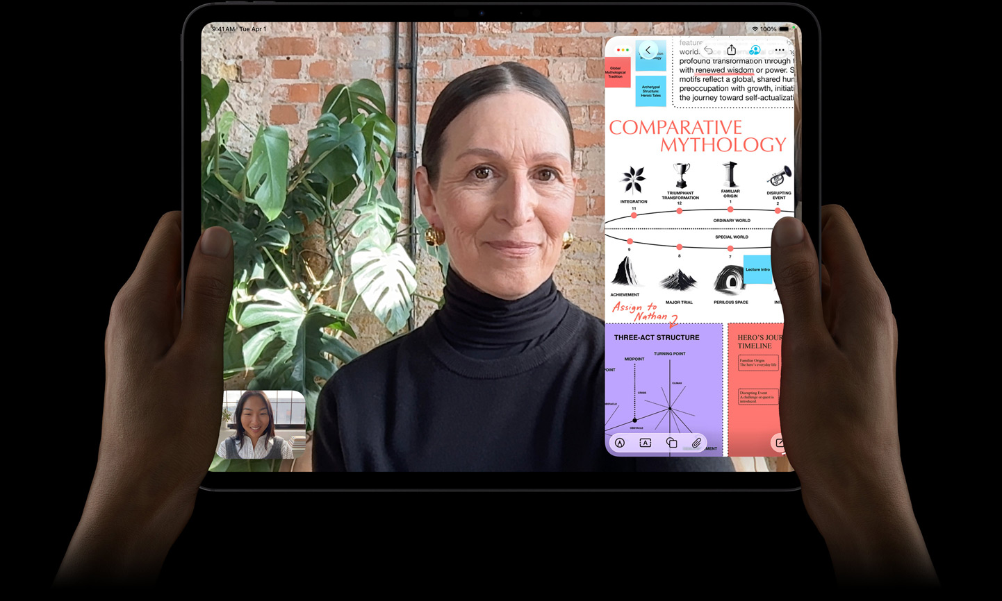 iPad Pro, Vorderansicht, Farbe Space Schwarz, linke und rechte Hand halten es im Querformat, gerundete Ecken, schwarzer Displayrand, das Display zeigt ein FaceTime Gespräch, das live übersetzt wird, und eine Lernapp zeigt eine Präsentation zu «Vergleichende Mythologie» mit Text, Diagrammen und handschriftlichen Notizen